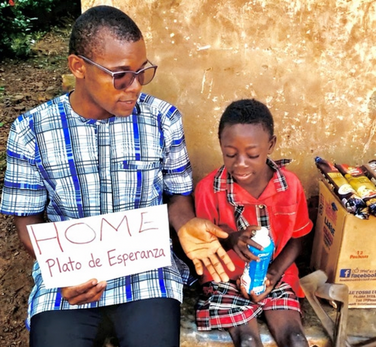 Voluntario entregando una botella a un niño con el cartel de la fundación